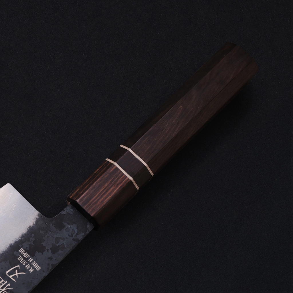 Close-up of Japanese knife’s durable non-slip ebony wood handle.